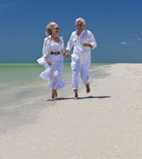 mature couple running on beach