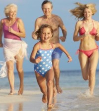 grand parents with family running on beach