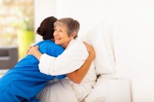 caregiver hugging elderly lady