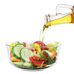 pouring olive oil on salad
